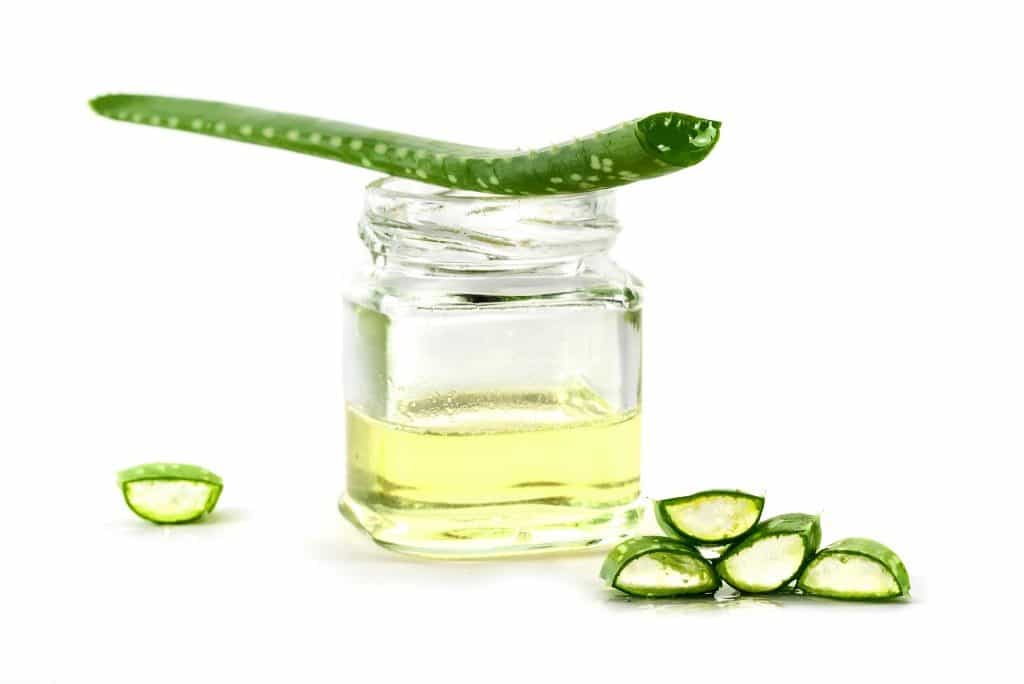 Aloe vera leaf, transparent slices and a glass with fresh gel, used for medicinal purposes, skin treatment and cosmetics, isolated on a white background, selected focus, narrow depth of field