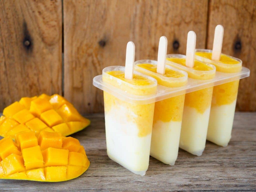 Homemade mango and yogurt popsicle for summer ice cream dessert concept.